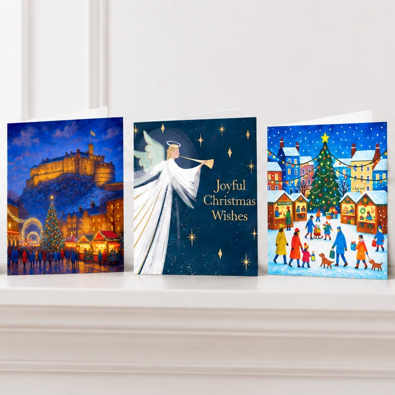 Three UNICEF charity Christmas cards standing on a white mantelpiece